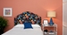a picture of a bedroom with floral peel and stick upholstered wall mounted headboard